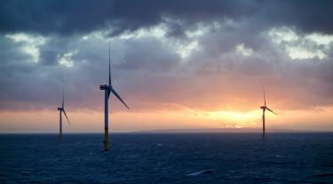 Offshore wind-farm in sunset and clouds